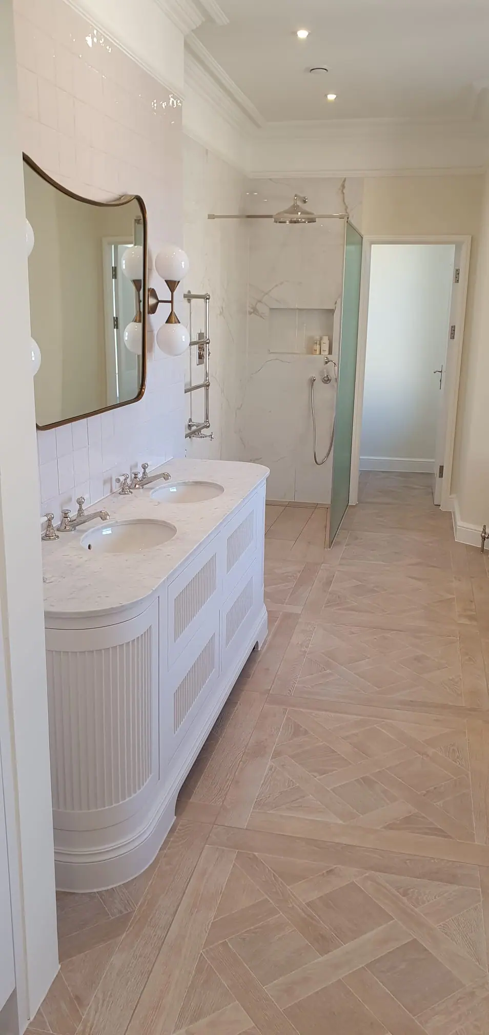 Bathroom with a double vanity, walk-in shower and chrome heated towel rail