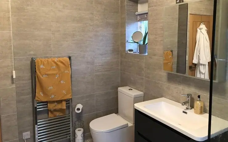Bathroom with grey tiles, a chrome heated towel rail and modern fittings