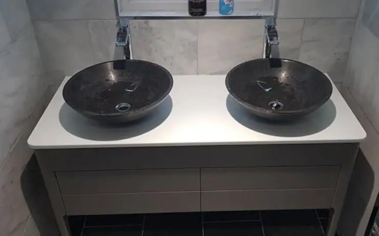 Twin vessel basins on a white vanity unit with chrome taps