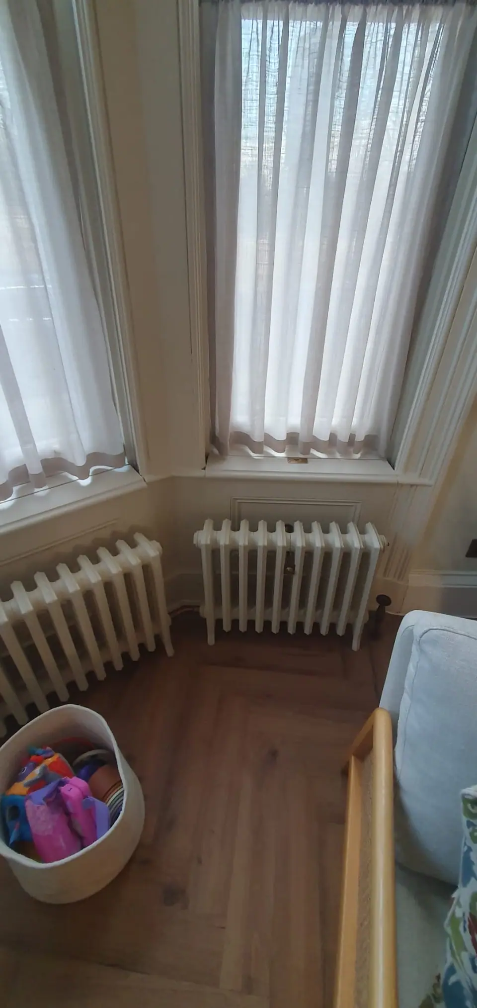White cast iron column radiators fitted beneath a bay window